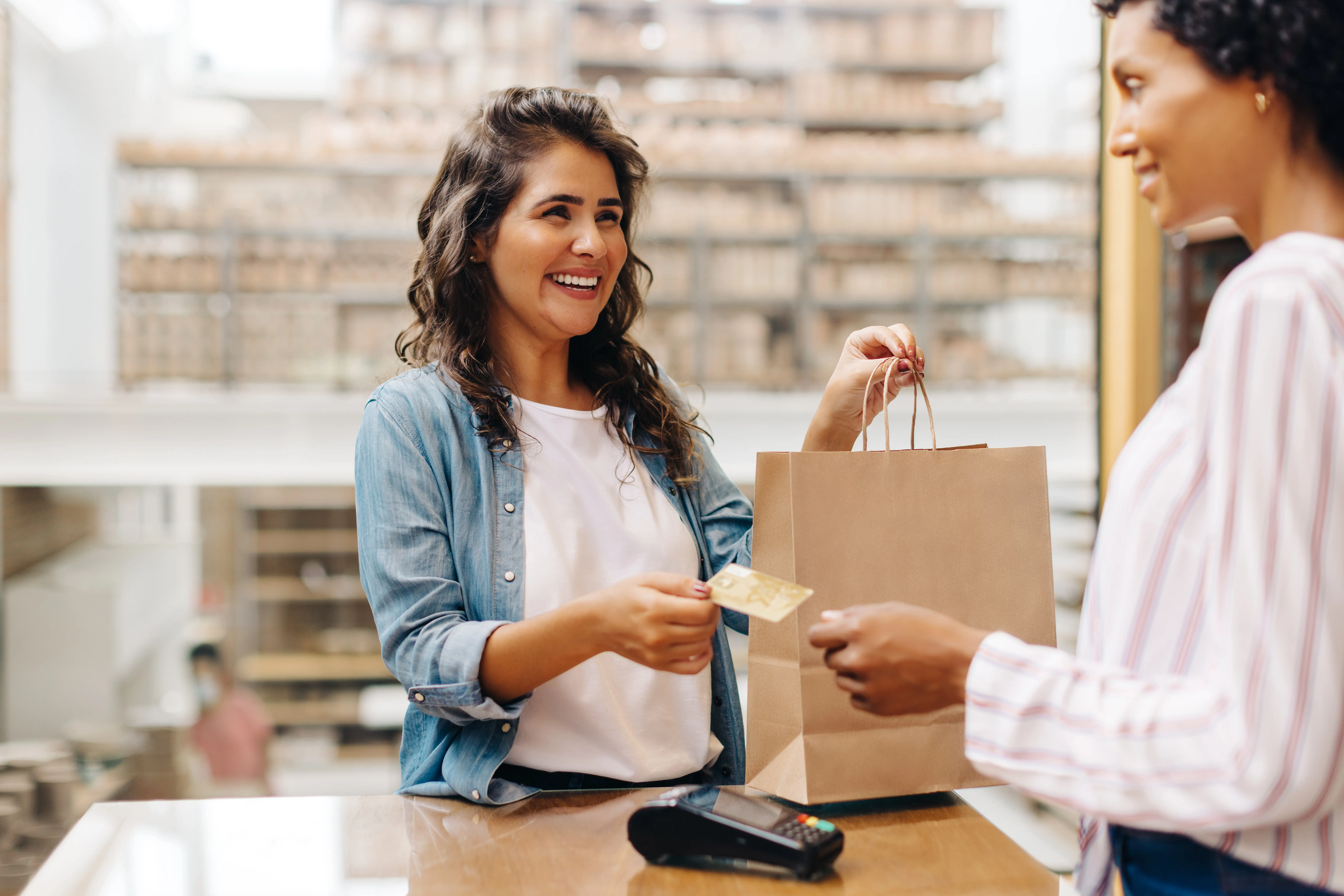 customer swiping payment at counter of brick and mortar shop