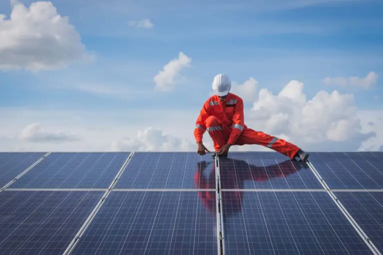 installer standing on solar panels under a partially cloudy sky