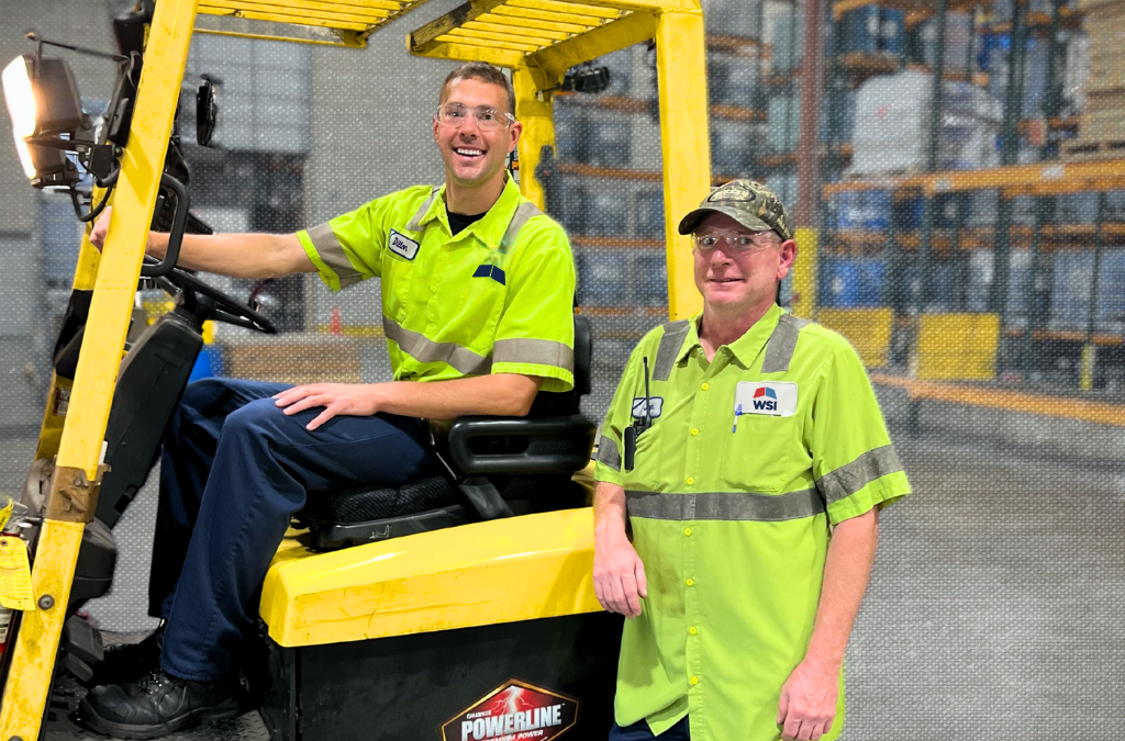 smiling warehouse workers and forklift proud of 3PL solutions