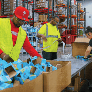 Three warehouse workers seamlessly fulfilling orders, representing the importance of labor management in warehousing and fulfillment
