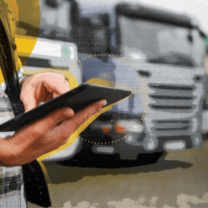 Man with tablet in front of trucks, representing the trends in transportation, and in part one, the trend of technology in transportation