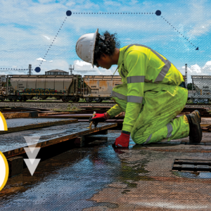 Image of worker writing next to train, representing the strategies that reduce rail demurrage.