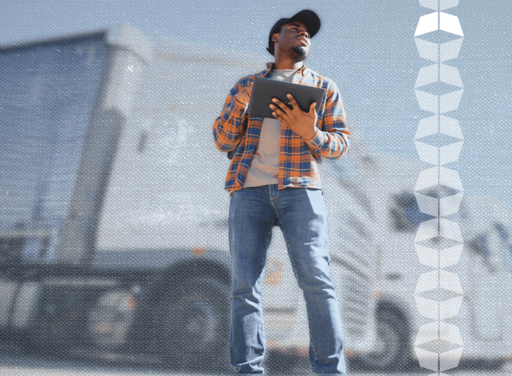 freight broker driver standing in front of tractor trailer