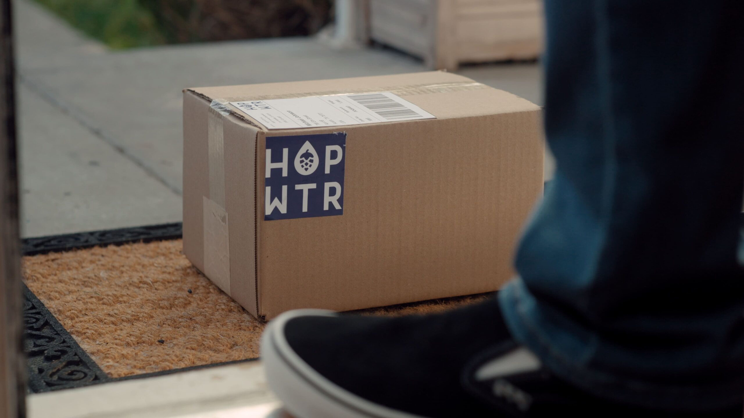 Package on doorstep with hopwtr logo