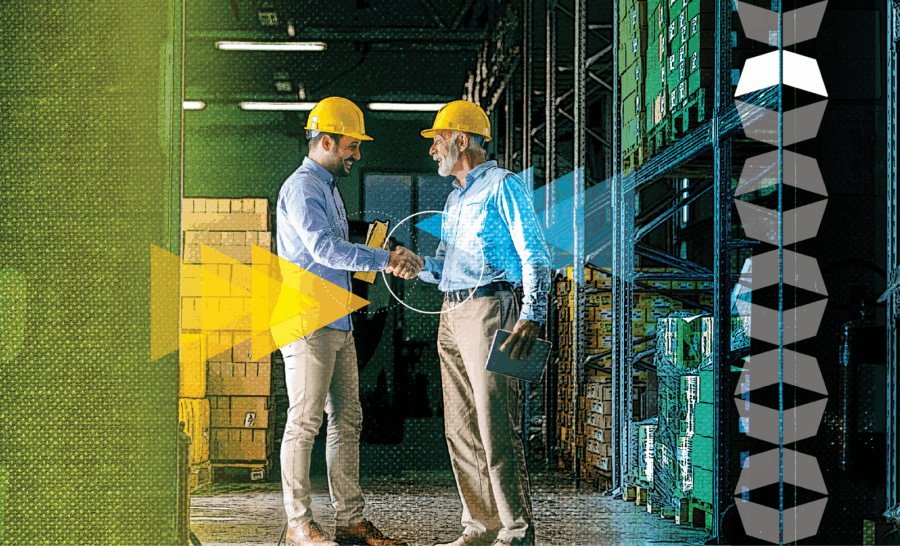 two men shaking hands in front of boxes in warehouse, representing finding a good manufacturing 3PL provider